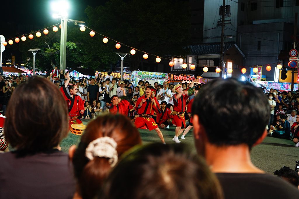 夜の交差点で阿波踊りの演舞をする寶船